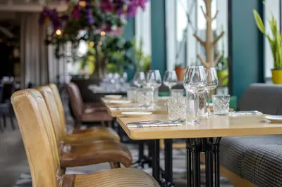 a row of tables in a restaurant with wine glasses at Holiday Inn Hotel Brussels Airport by IHG in Diegem