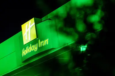 a green sign on the side of a building at Holiday Inn Hotel Brussels Airport by IHG in Diegem