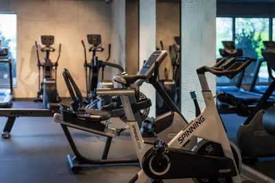 a gym with several cardio machines in a room at Holiday Inn Hotel Brussels Airport by IHG in Diegem