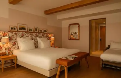 a bedroom with a large white bed and a table at 9Hotel Chelton in Brussels