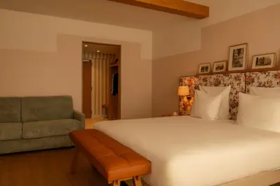 a bedroom with a bed and a couch and a chair at 9Hotel Chelton in Brussels