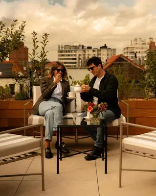 a man and woman sitting at a table on a roof at 9Hotel Chelton in Brussels
