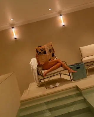 a woman sitting on a chair with a stack of boxes at 9Hotel Chelton in Brussels