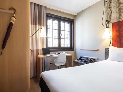 a hotel room with a bed and a desk with a laptop at ibis Hotel Brussels off Grand'Place in Brussels