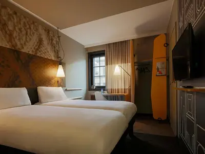 a hotel room with two beds and a television at ibis Hotel Brussels off Grand'Place in Brussels