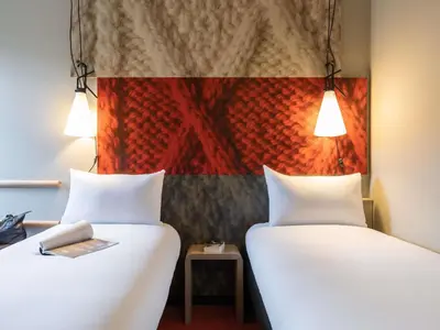 two white beds in a room with a painting at ibis Hotel Brussels off Grand'Place in Brussels