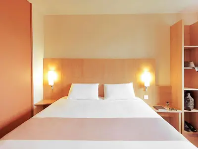 a bedroom with a large white bed with two pillows at ibis Hotel Brussels Expo Atomium in Brussels