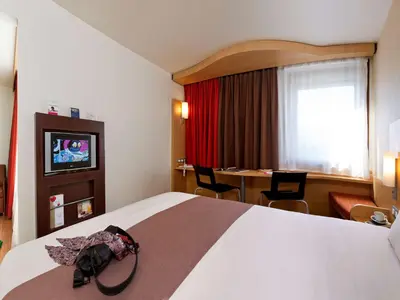 a hotel room with a large bed and a table at ibis Hotel Brussels Expo Atomium in Brussels