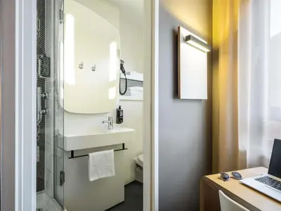 a bathroom with a sink and a shower and a laptop at ibis Gent Centrum Opera in Ghent