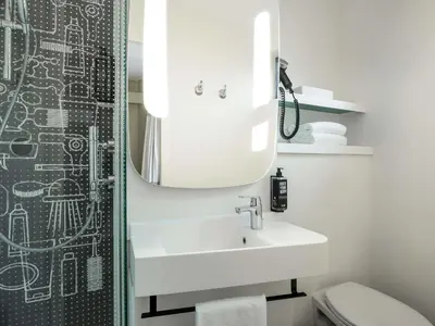 a bathroom with a sink and a mirror at ibis Gent Centrum Opera in Ghent