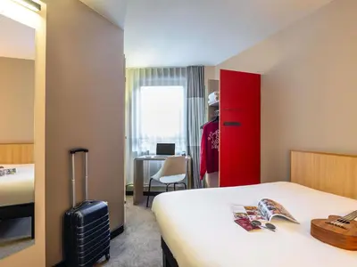 a hotel room with a bed and a red cabinet at ibis Gent Centrum Opera in Ghent
