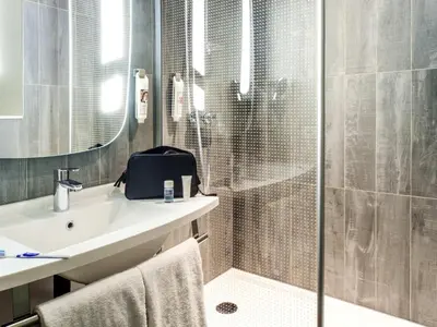 a bathroom with a shower and a sink and a toilet at ibis Gent Centrum St. Baafs Kathedraal in Ghent