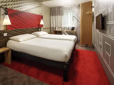 a hotel room with a large bed and a red carpet at ibis Gent Centrum St. Baafs Kathedraal in Ghent