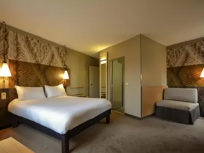a hotel room with a large bed and a chair at ibis Gent Centrum St. Baafs Kathedraal in Ghent