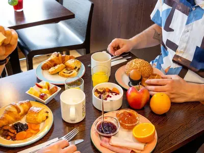 a table with plates of breakfast food on it at ibis Leuven Centrum in Leuven