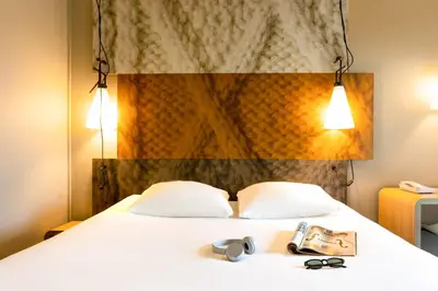 a hotel room with a bed with two pairs of glasses at ibis Leuven Centrum in Leuven