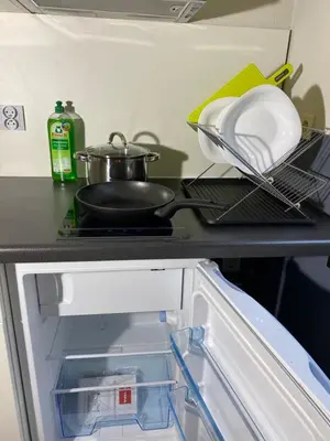 an open refrigerator with dishes and a pan on a shelf at Hotel Fauwater in Kasterlee