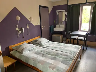 a bedroom with a large bed and a sink at Hotel Fauwater in Kasterlee
