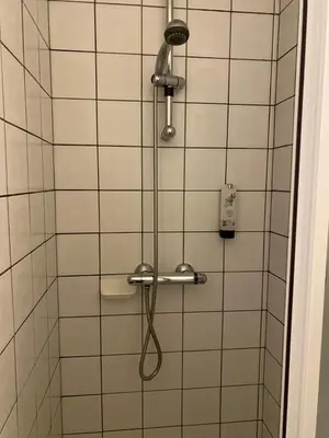 a shower with a shower head in a bathroom at Hotel Fauwater in Kasterlee