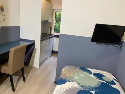 a room with a desk and a table and a chair at Hotel Fauwater in Kasterlee