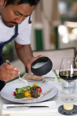 a man holding a bottle of wine next to a plate of food at Stanhope Hotel by Thon Hotels in Brussels