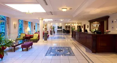 a lobby with a waiting area with chairs and tables at Stanhope Hotel by Thon Hotels in Brussels
