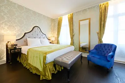 a bedroom with a bed and a blue chair at Stanhope Hotel by Thon Hotels in Brussels