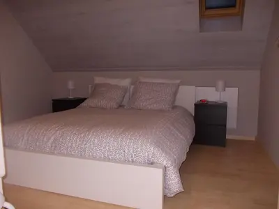 a bedroom with a white bed with two night stands at Het Zolderhuis in Arendonk