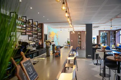 a restaurant with a bar and tables and chairs at Tulip Inn Antwerpen in Antwerp