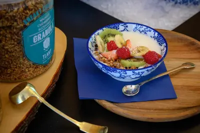 a bowl of cereal and a bowl of fruit on a table at Tulip Inn Antwerpen in Antwerp