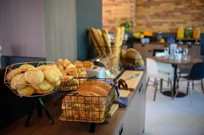 a counter with baskets of bread on a table at Tulip Inn Antwerpen in Antwerp