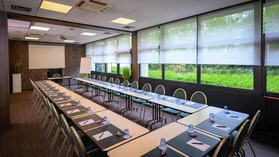 a row of tables in a room with large windows at Tulip Inn Antwerpen in Antwerp