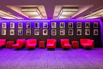 a room with red chairs and pictures on the wall at nhow Brussels Bloom in Brussels