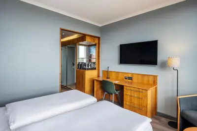 a hotel room with a bed and a desk and a television at Crowne Plaza Antwerpen by IHG in Antwerp