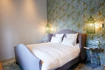 a bedroom with a bed with a floral wallpaper at Hotel Groenendaal in Hoeilaart