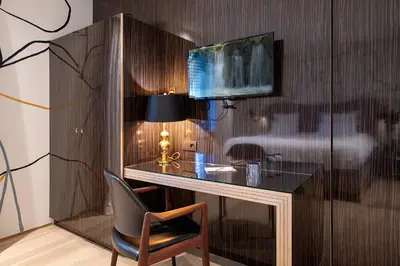 a desk with a chair and a lamp in a room at Hotel Groenendaal in Hoeilaart