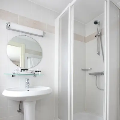 a white bathroom with a sink and a shower at Theater Hotel Leuven Centrum in Leuven