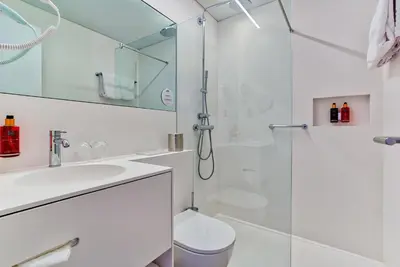 a bathroom with a shower and a toilet and a sink at Hotel Astoria Gent in Ghent