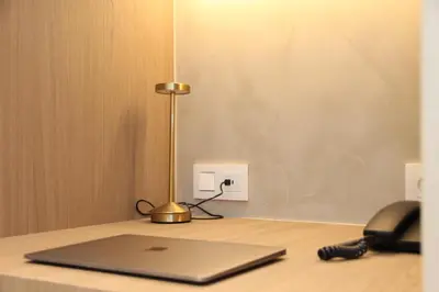 a laptop computer sitting on a desk with a phone at Hotel Astoria Gent in Ghent