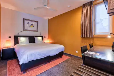 a bedroom with a large bed and a window at Hotel Astoria Gent in Ghent