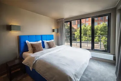 a bedroom with a large bed and a large window at Hotel The Neufchatel in Brussels