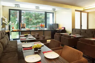 a restaurant with tables and chairs and a large window at Hotel The Neufchatel in Brussels