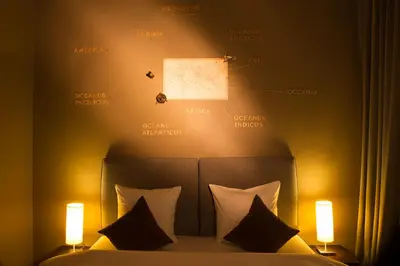 a bedroom with a bed with two lights on it at Hotel The Neufchatel in Brussels