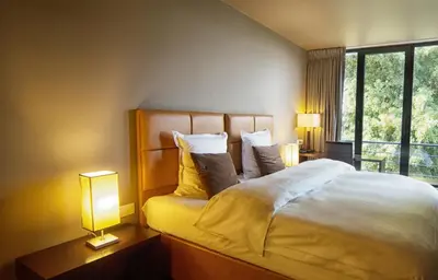 a bedroom with a bed with two lamps and a window at Hotel The Neufchatel in Brussels