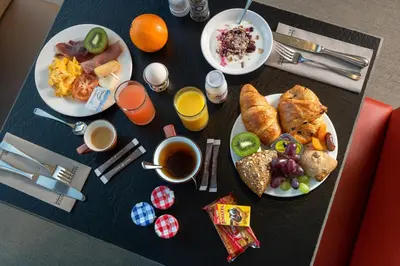 a table topped with plates of breakfast foods and drinks at Martin's Klooster in Leuven