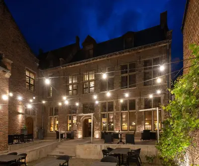 a large brick building with lights at night at Martin's Klooster in Leuven