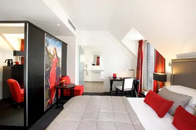 a bedroom with a king sized bed and a desk at Martin's Klooster in Leuven