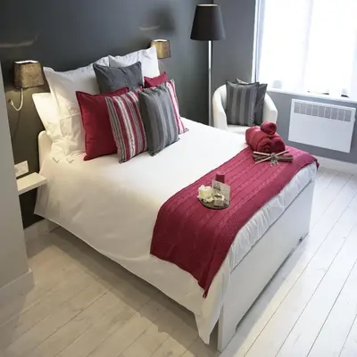 a large white bed with red and gray pillows at B&B Be In Brussels in Brussels