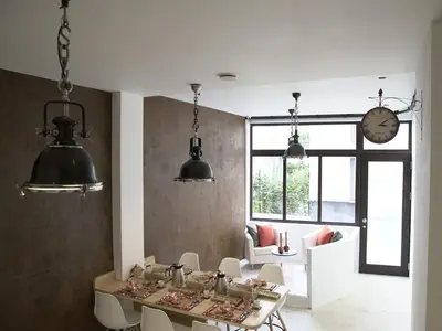 a dining room with a table and chairs and a clock at B&B Be In Brussels in Brussels