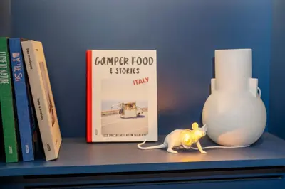 a toy cat sitting on a shelf next to books at Holiday Inn Express & Suites Ghent by IHG in Ghent